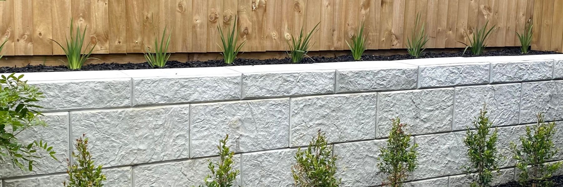 Long Stonebloc retaining wall at the back of a infill housing development