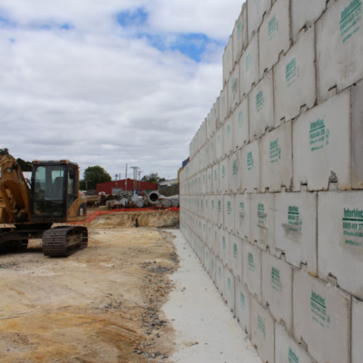 Digger next to an retaining wall made from Interbloc mass concrete blocks