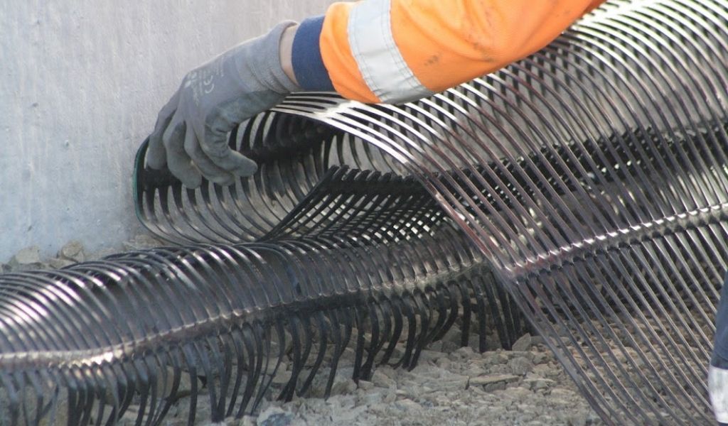 Connecting geogrid that's embedded in a 1200 Interbloc block to more geogrid that lies across the backfill