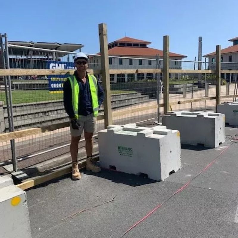 Contractor standing in front of Interbloc concrete blocks used for hoardings