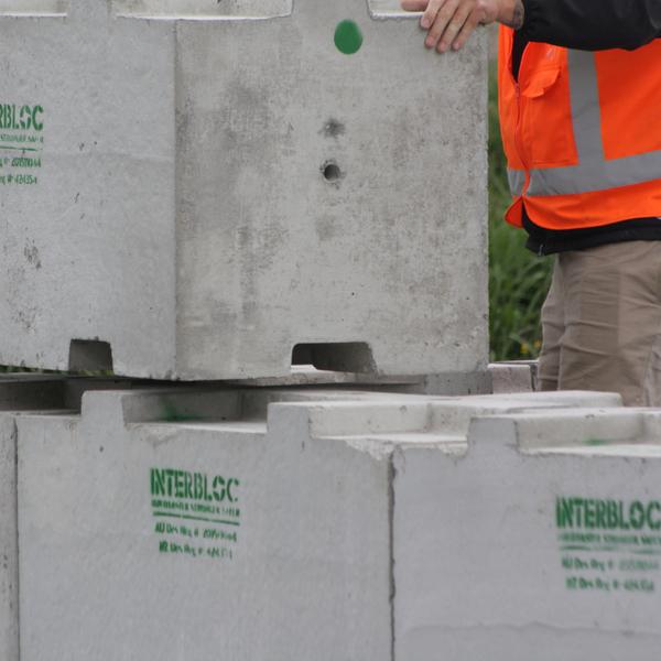 Man guiding an Interbloc concrete block into place
