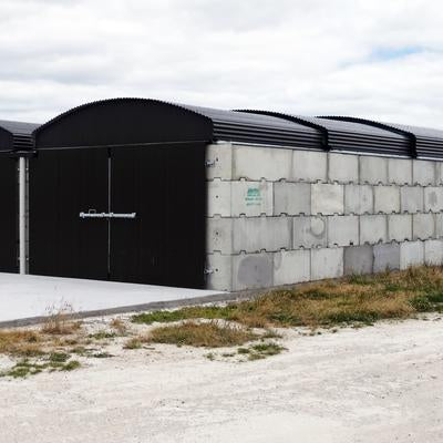 Interbloc concrete blocks forming a fertiliser bin with a black retractable roof and black doors